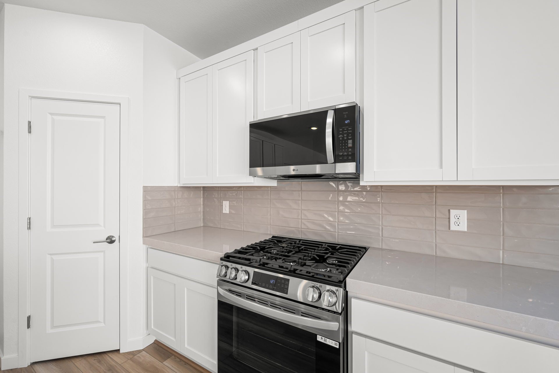A kitchen with white cabinets.