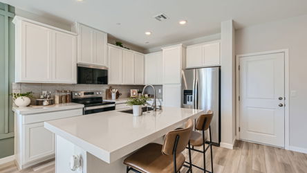 A kitchen with white cabinets.