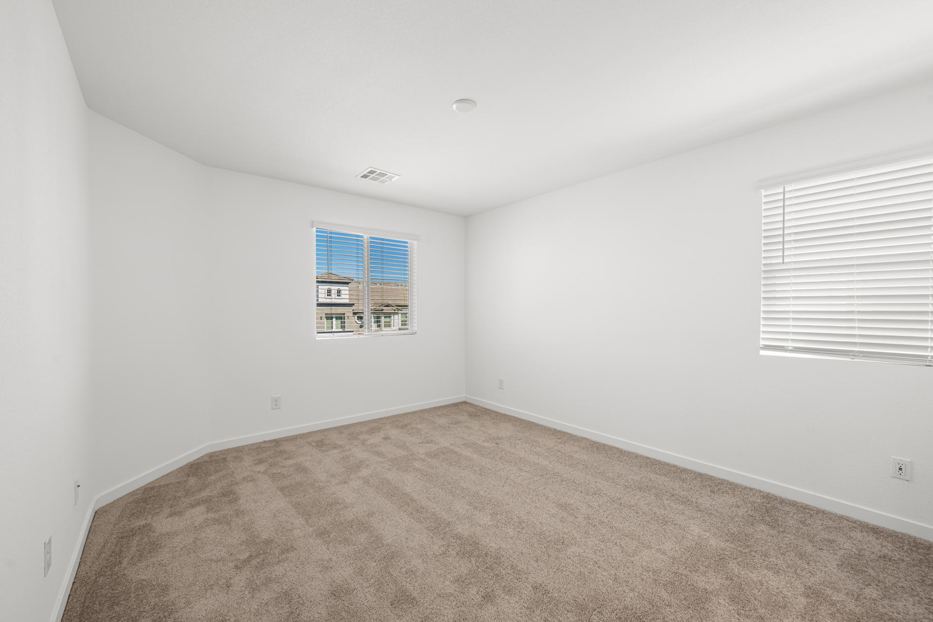 A room with a carpet and a window.