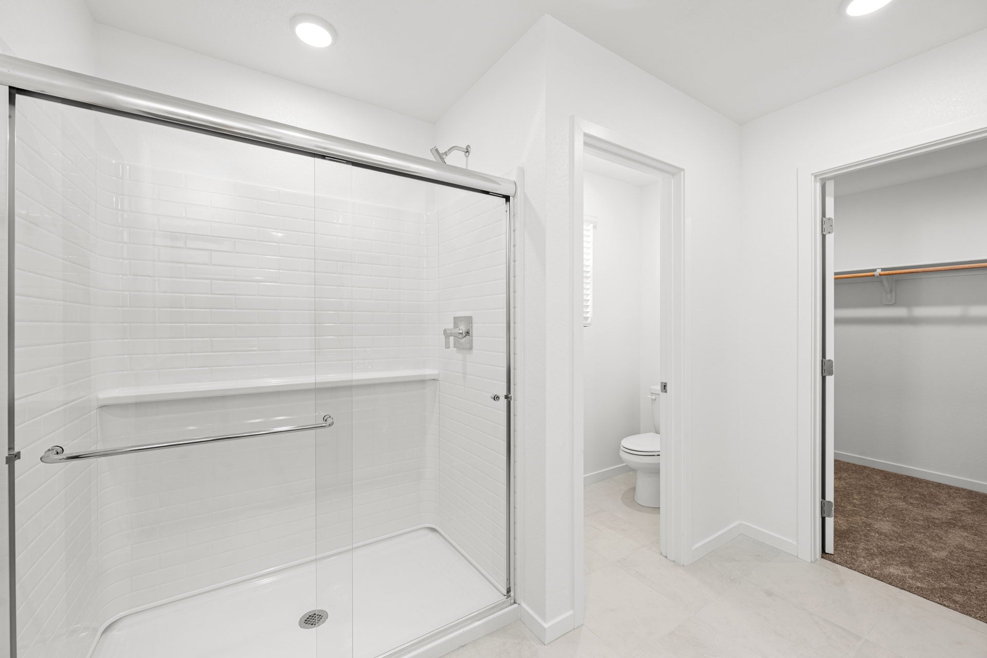 A bathroom with a shower unit and toilet.