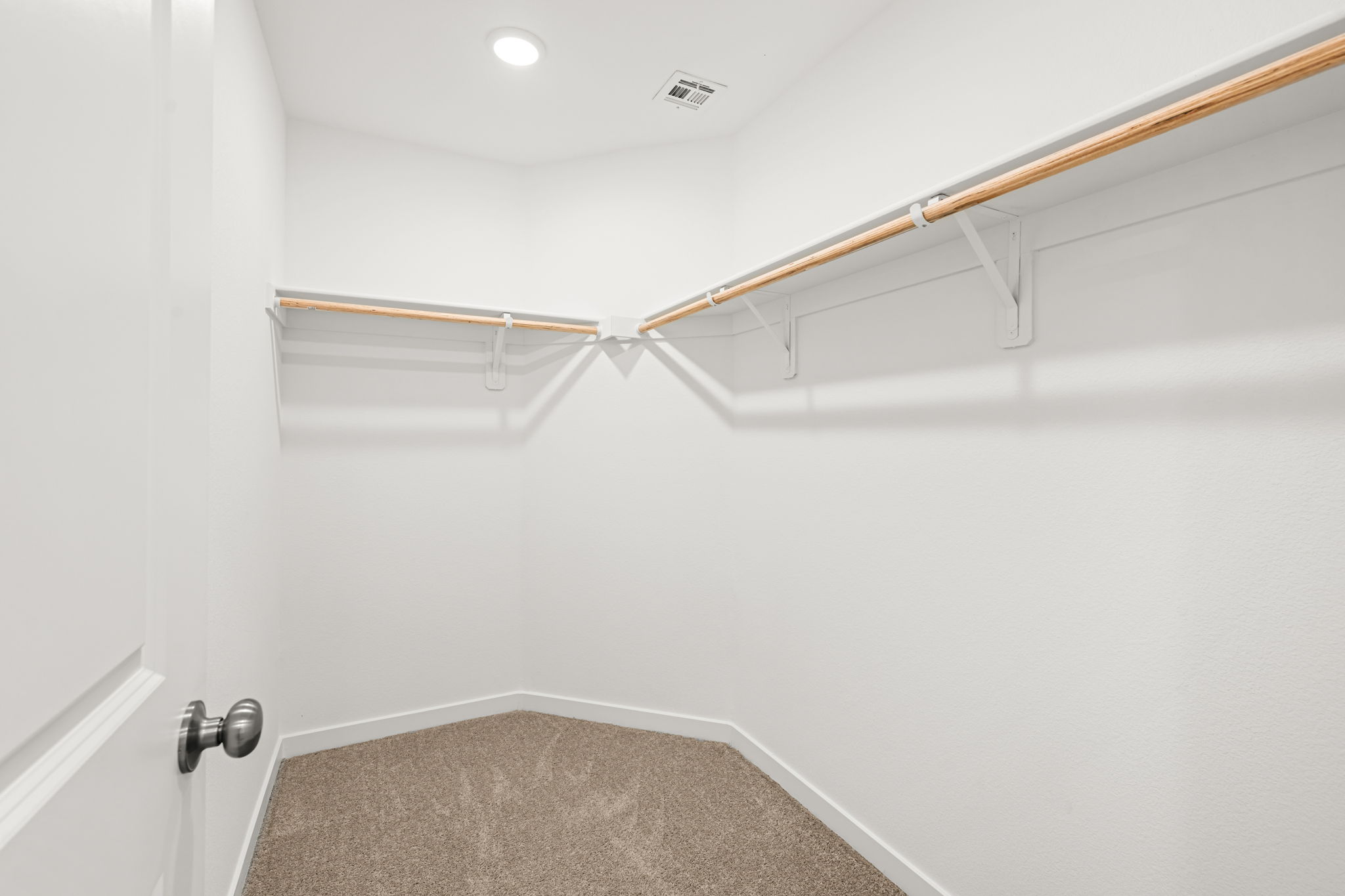 A white wall with a metal bar.