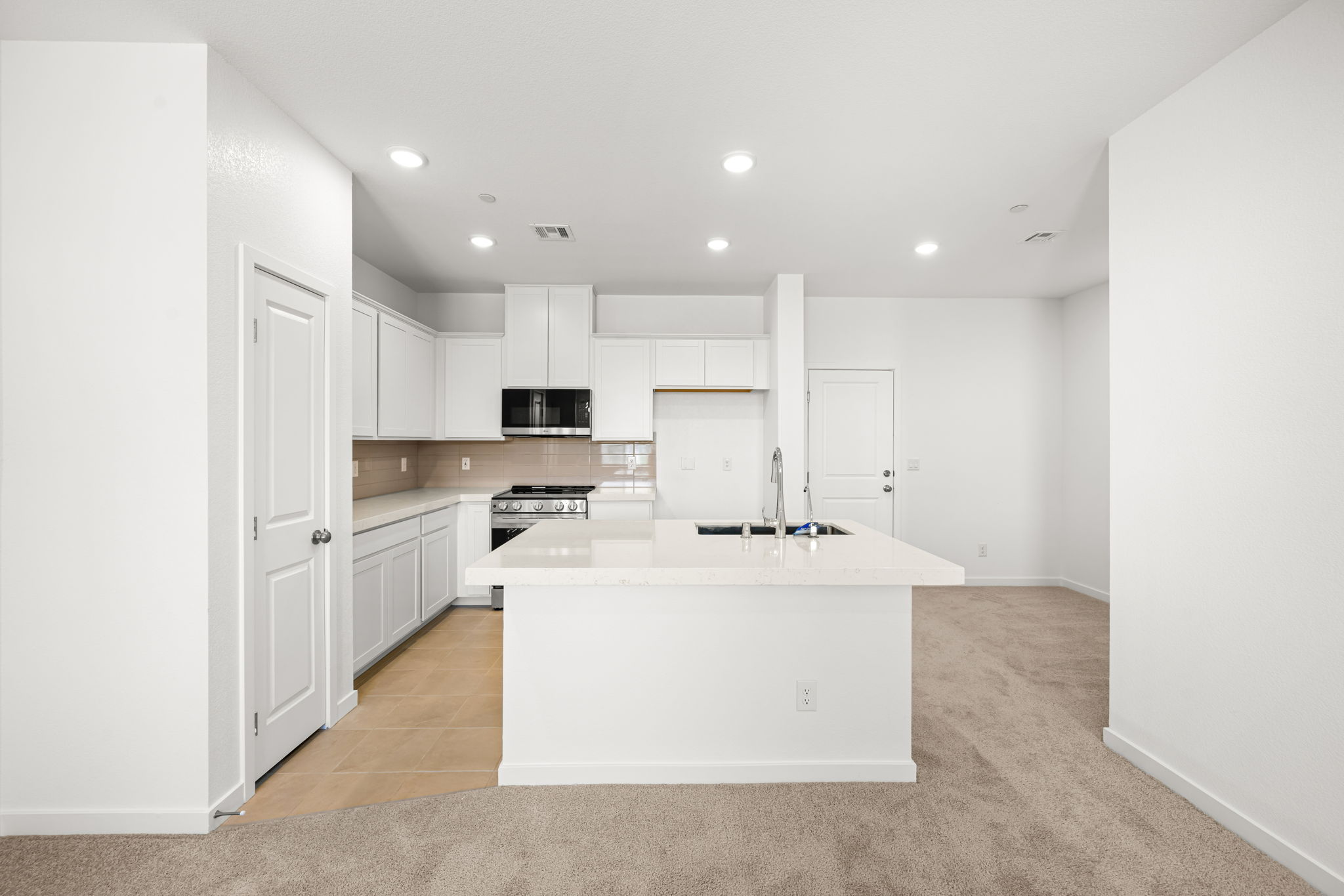 A kitchen with white cabinets.