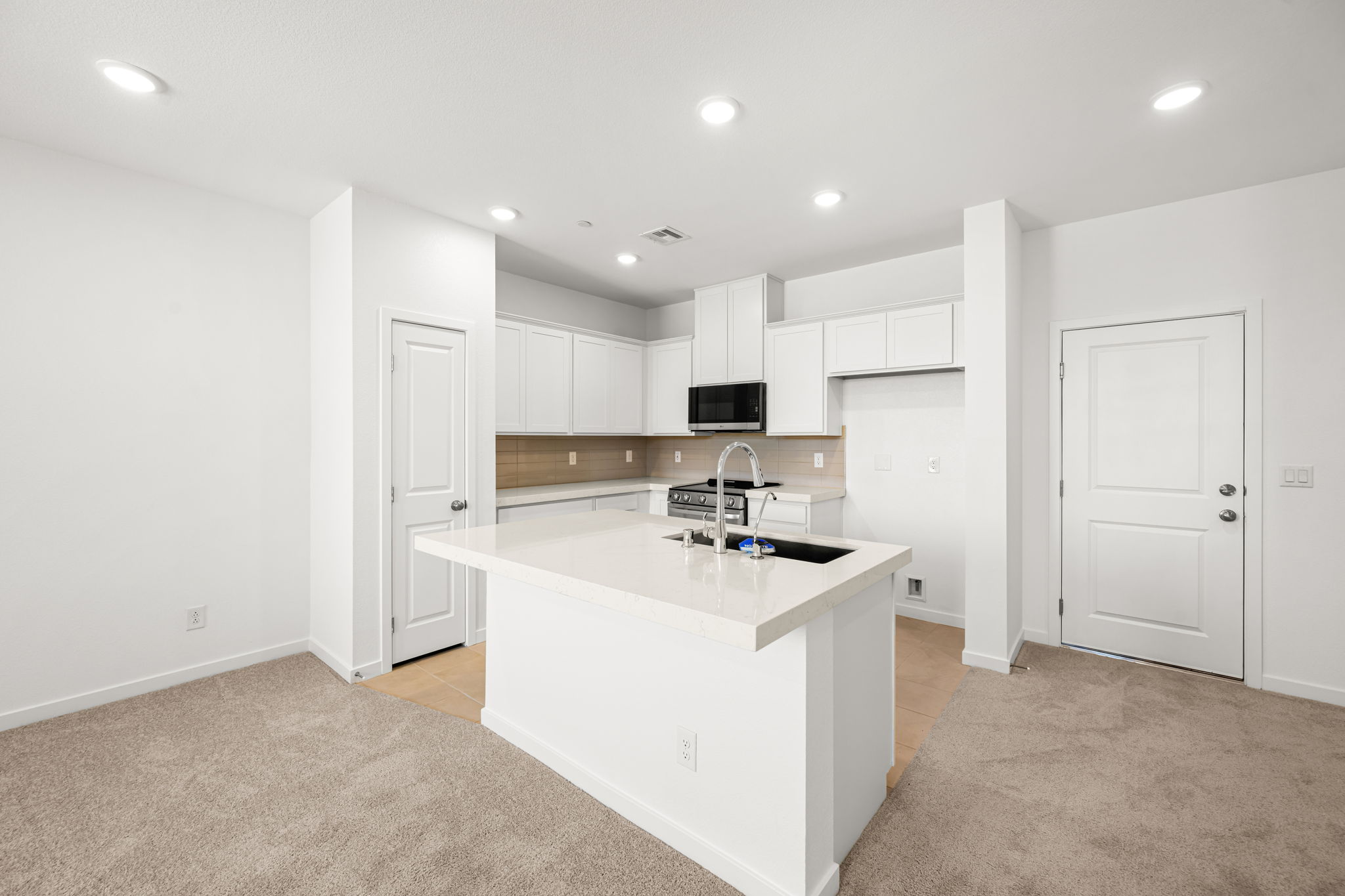 A kitchen with white cabinets.