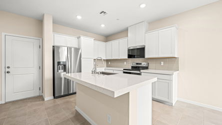 A kitchen with white cabinets.