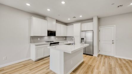 A kitchen with white cabinets.