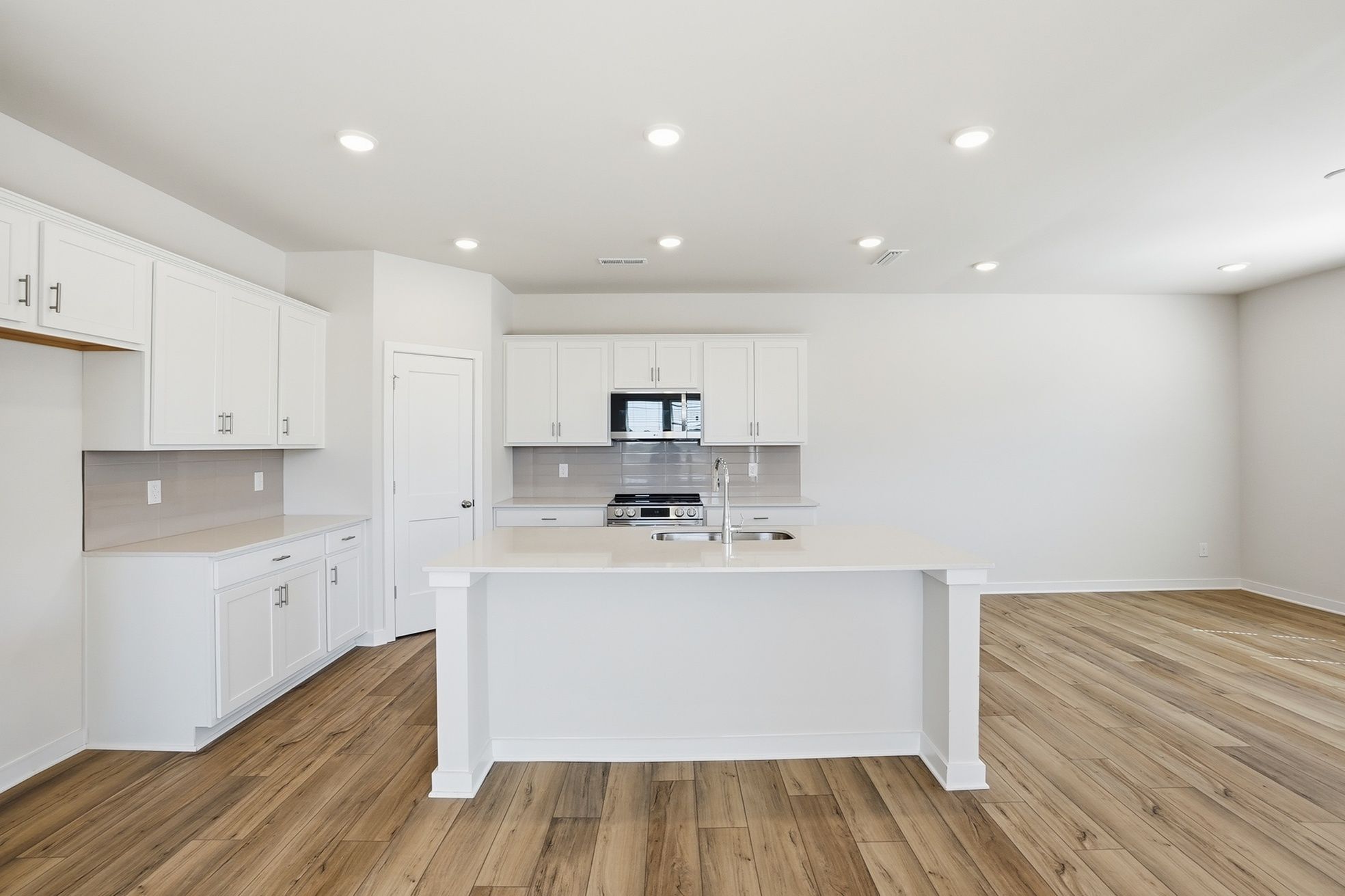 A kitchen with white cabinets.
