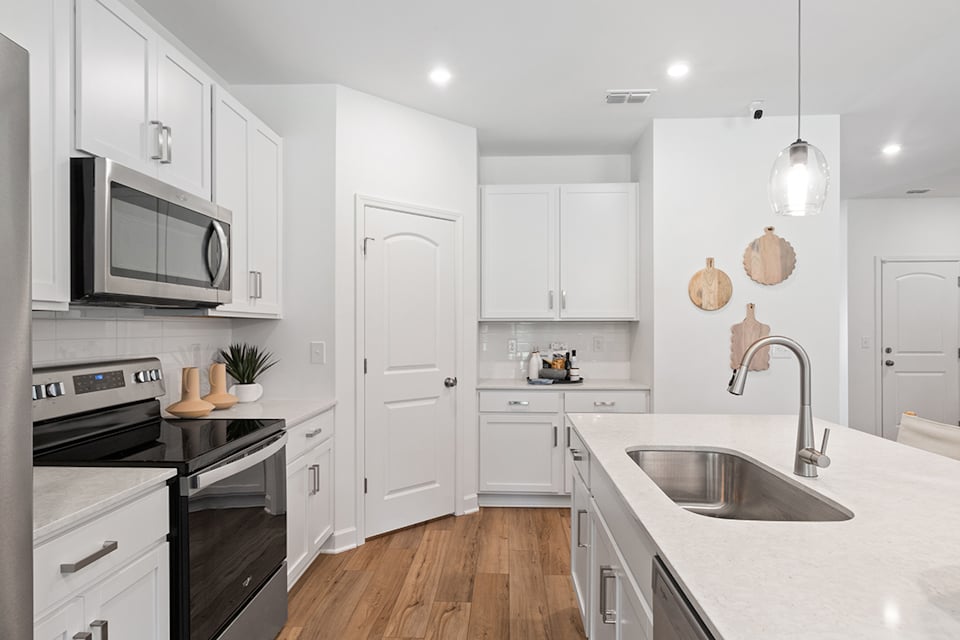 A kitchen with white cabinets.