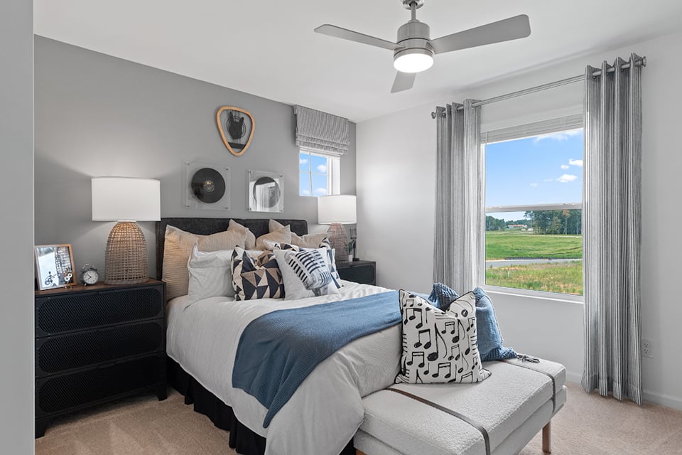 A bedroom with a large window.