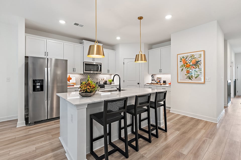 A kitchen with a dining table and a refrigerator.