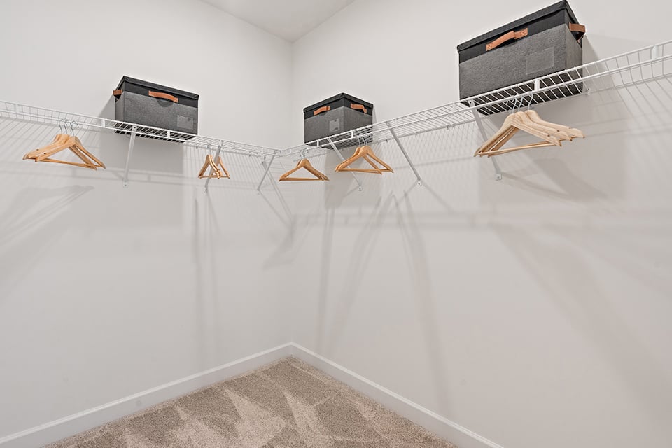 A white wall with a few wooden benches and a few black boxes.