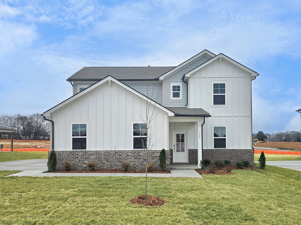 A white house with a lawn.