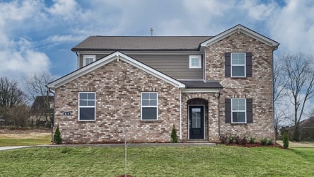 A brick house with a grass yard.