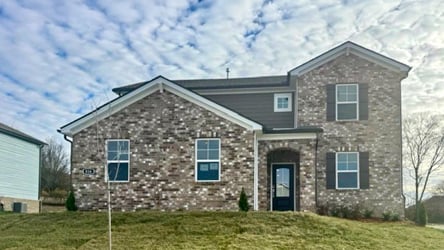 A brick building with a grass yard.