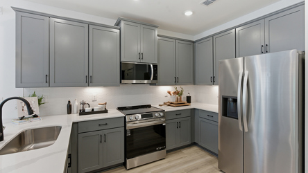 A kitchen with white cabinets.