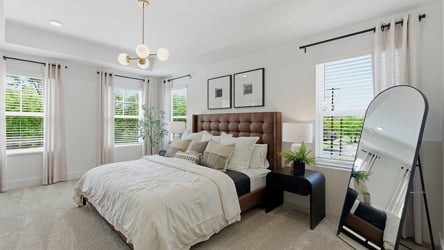 A bedroom with a large mirror.