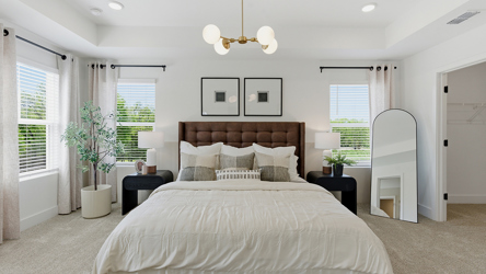 A bedroom with a bed and a chandelier.