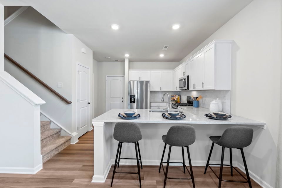 A kitchen with white cabinets.
