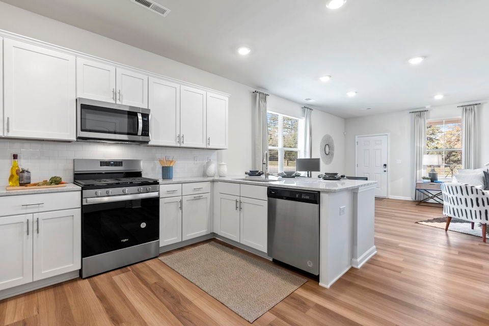 A kitchen with white cabinets.