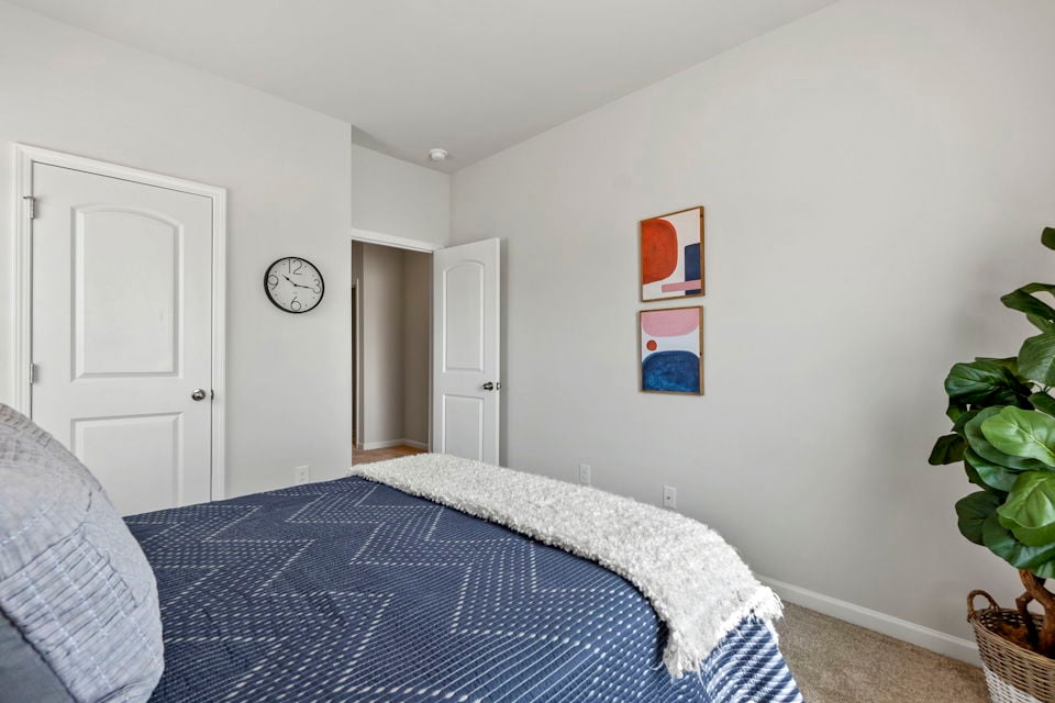 A bedroom with a bed and a clock.