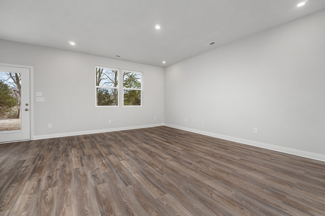 A room with a wood floor and windows.