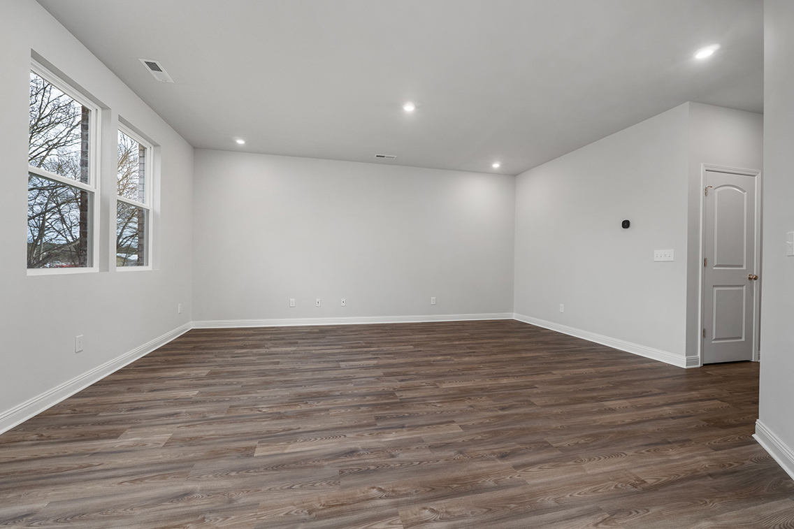 A room with a wood floor and windows.