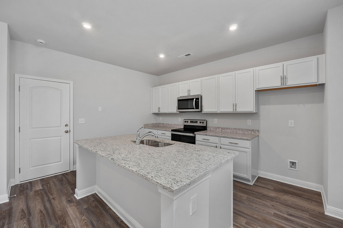 A kitchen with white cabinets.