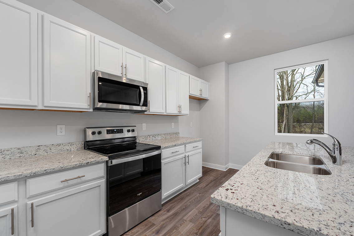 A kitchen with white cabinets.