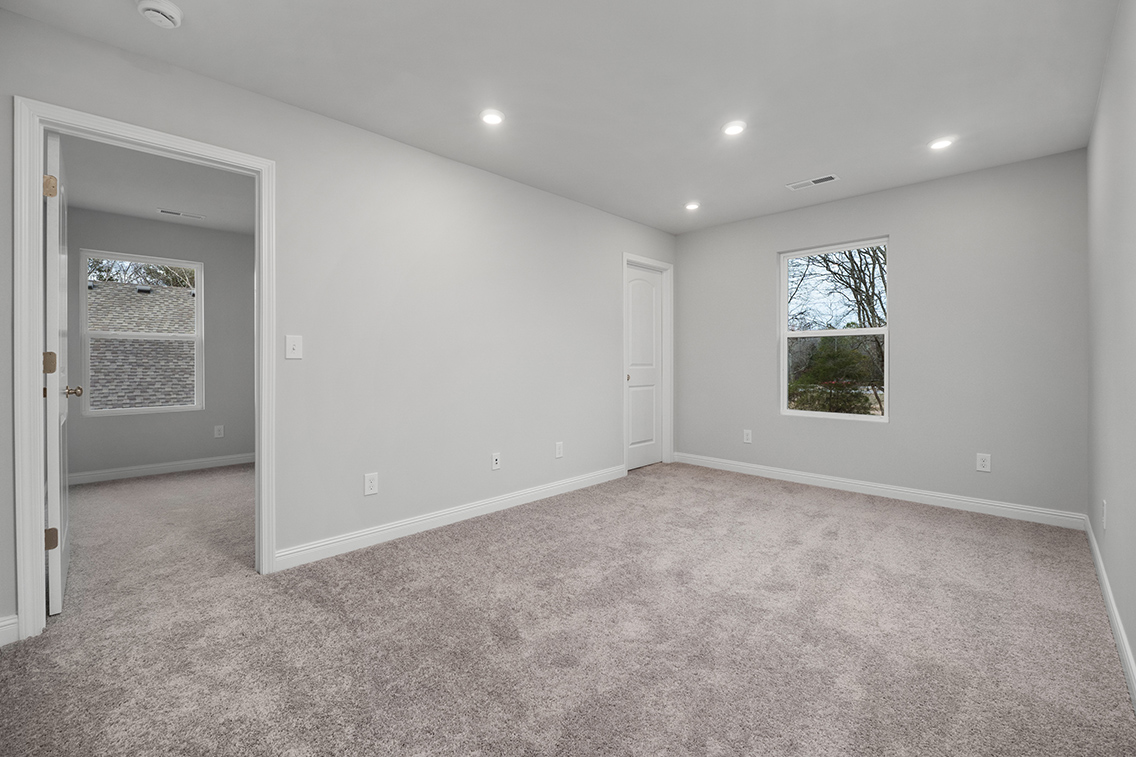A room with a carpet and a window.