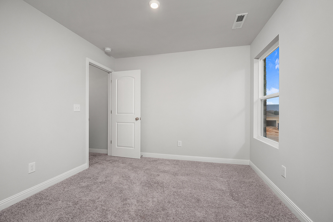 A room with a carpet and a door.