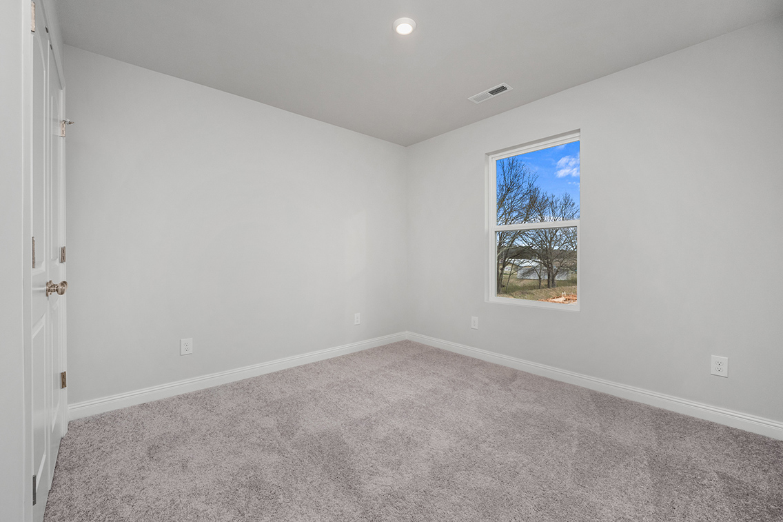 A room with a window and a carpet.