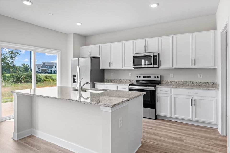 A kitchen with white cabinets.