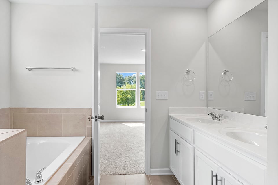 A bathroom with a tub sink and a shower unit.