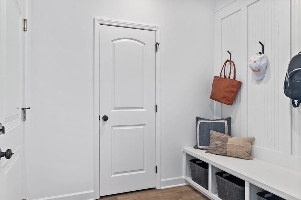 A room with white doors and a table with a basket and a basket.