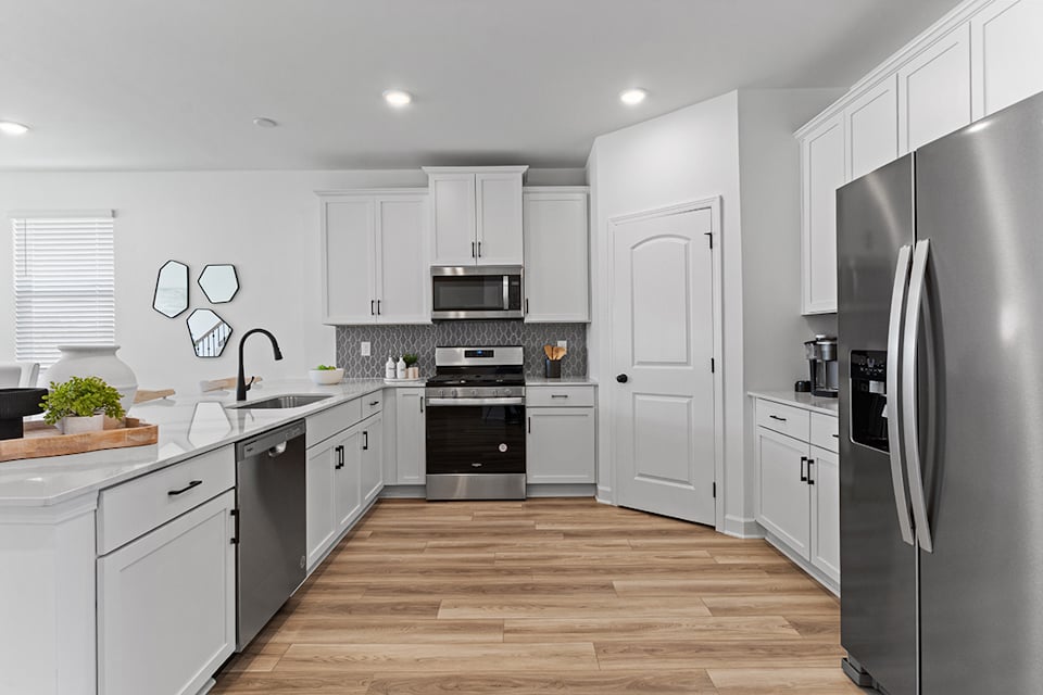 A kitchen with white cabinets.