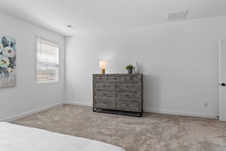 A room with a dresser and a lamp.