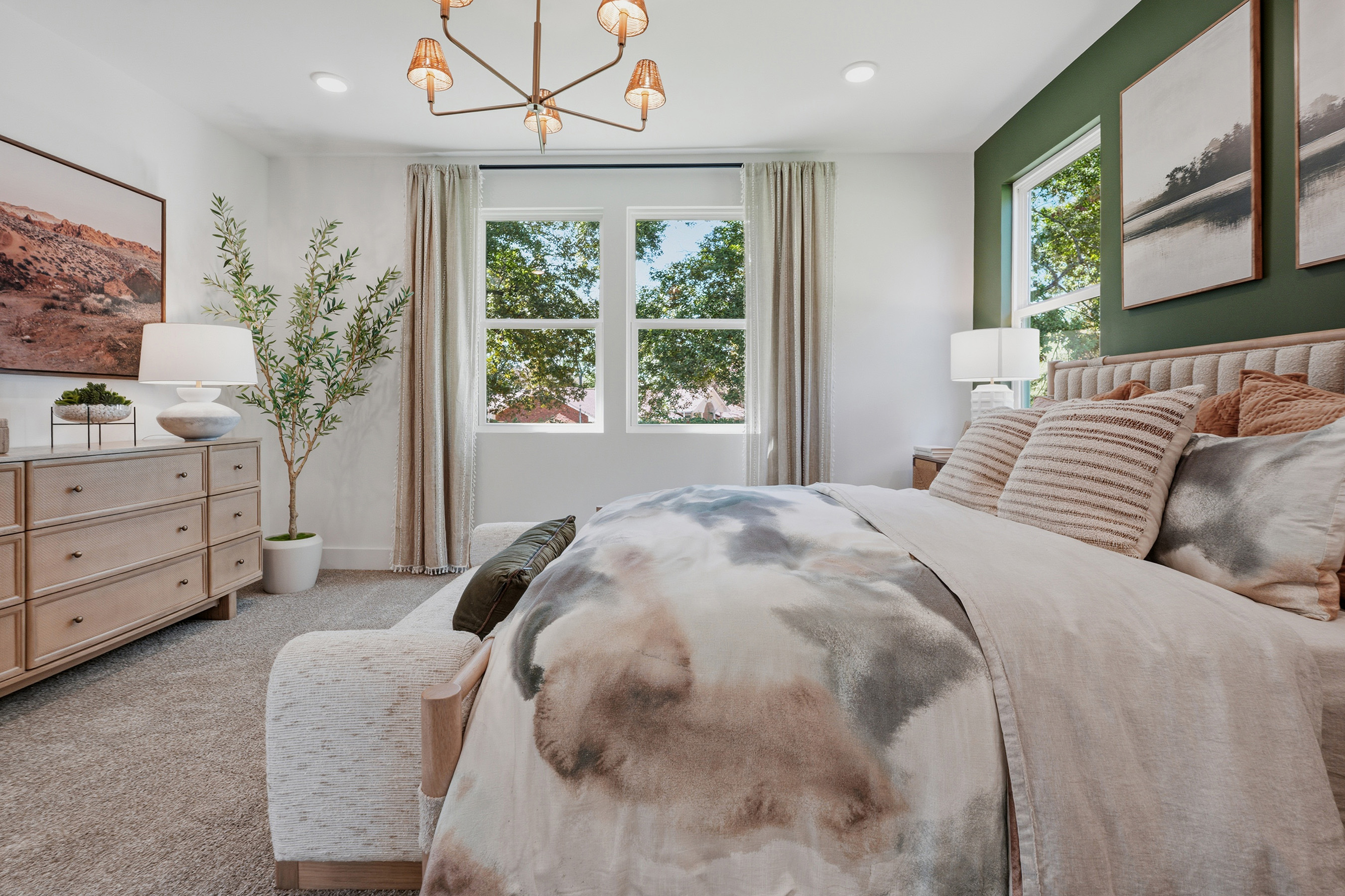 A bedroom with a bed and a chandelier.