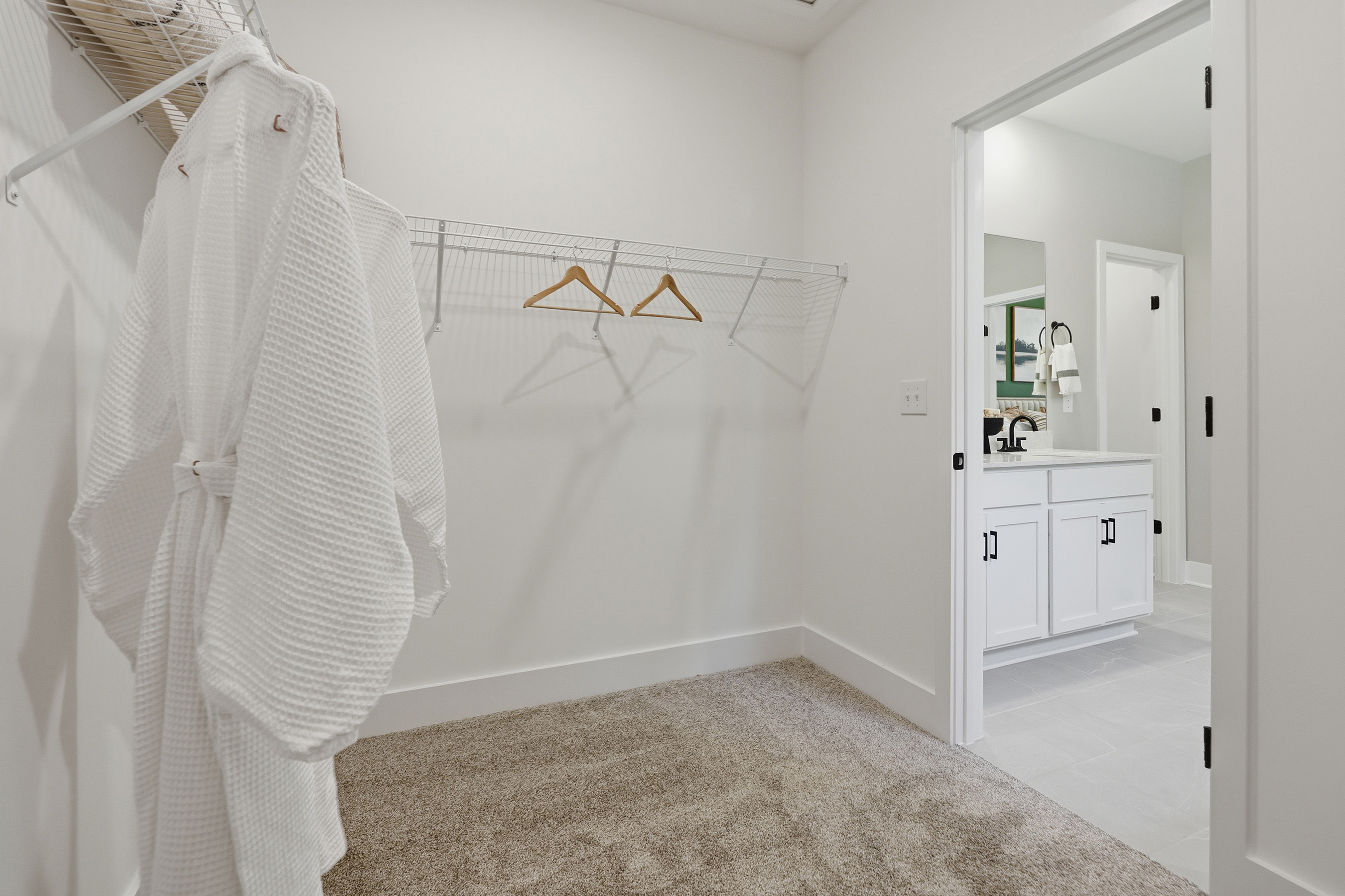 A white room with a mirror and a white wall with a white curtain.