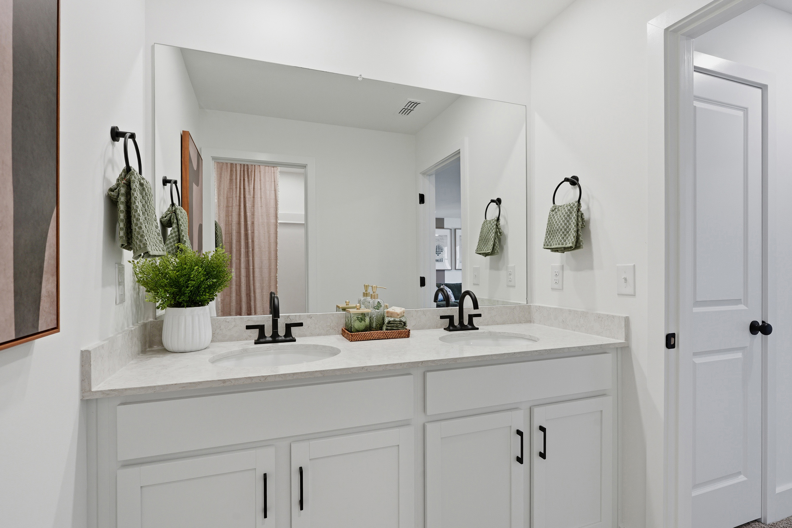 A bathroom with white cabinets.