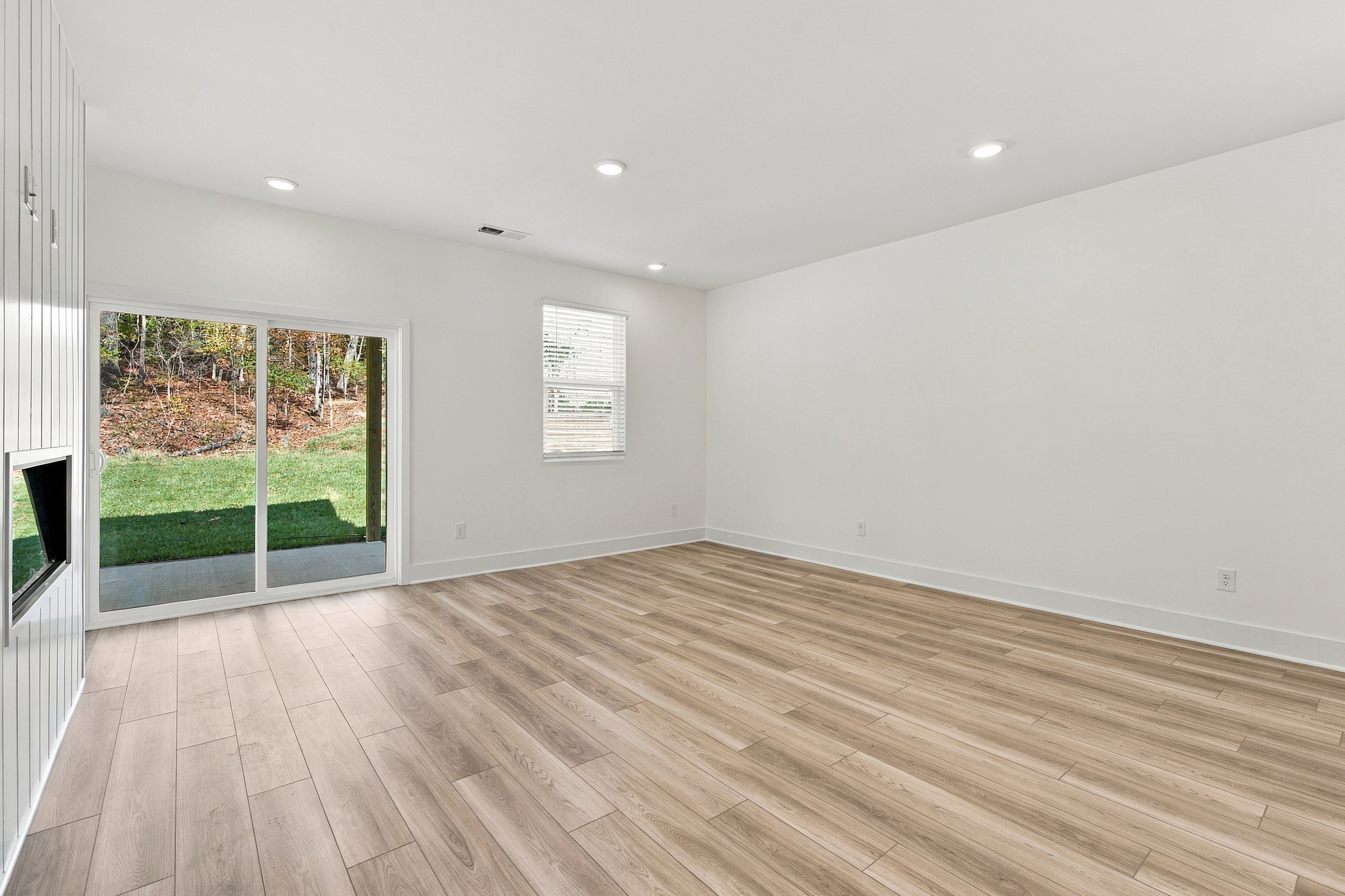 A room with a wood floor and a window.