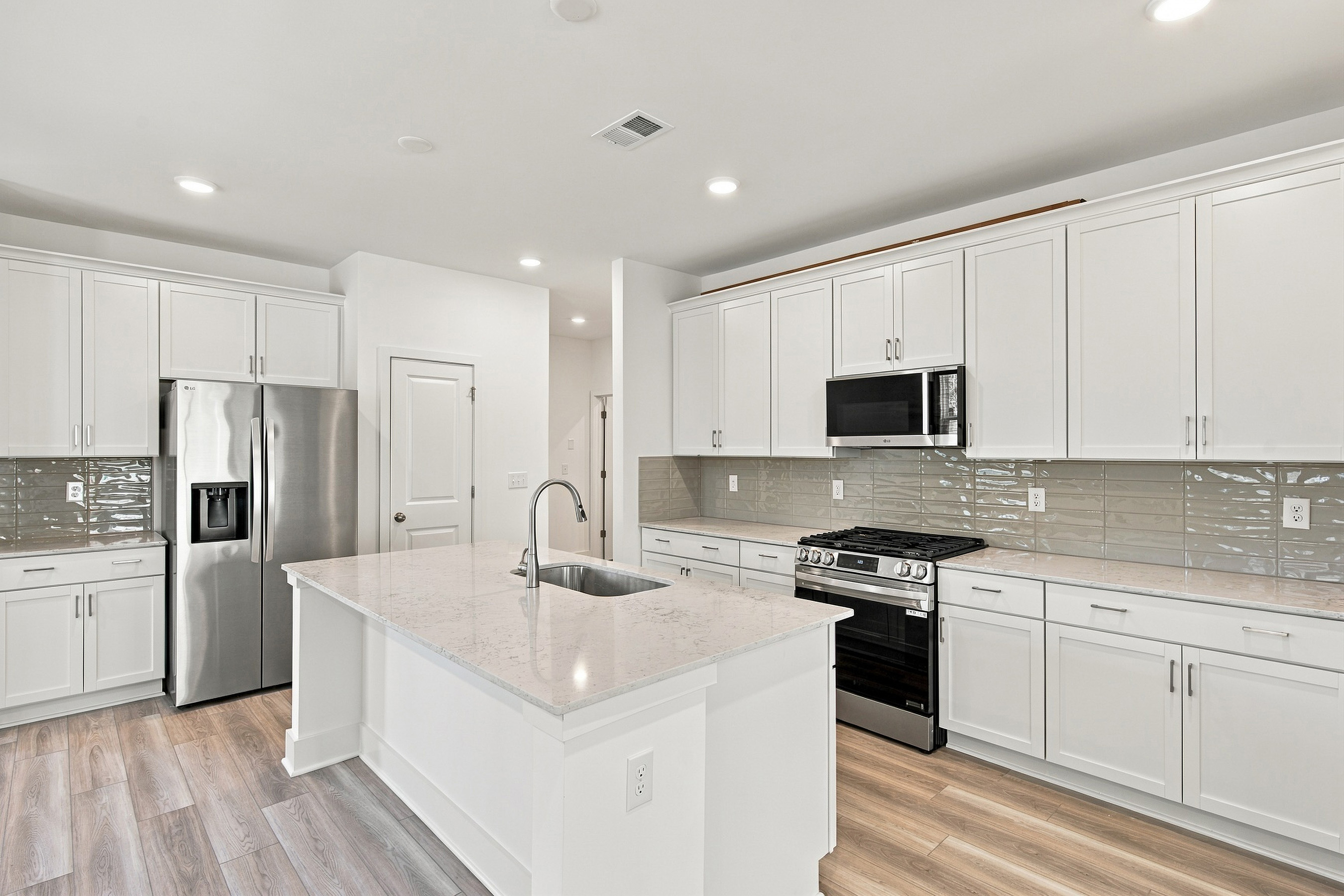 A kitchen with white cabinets.