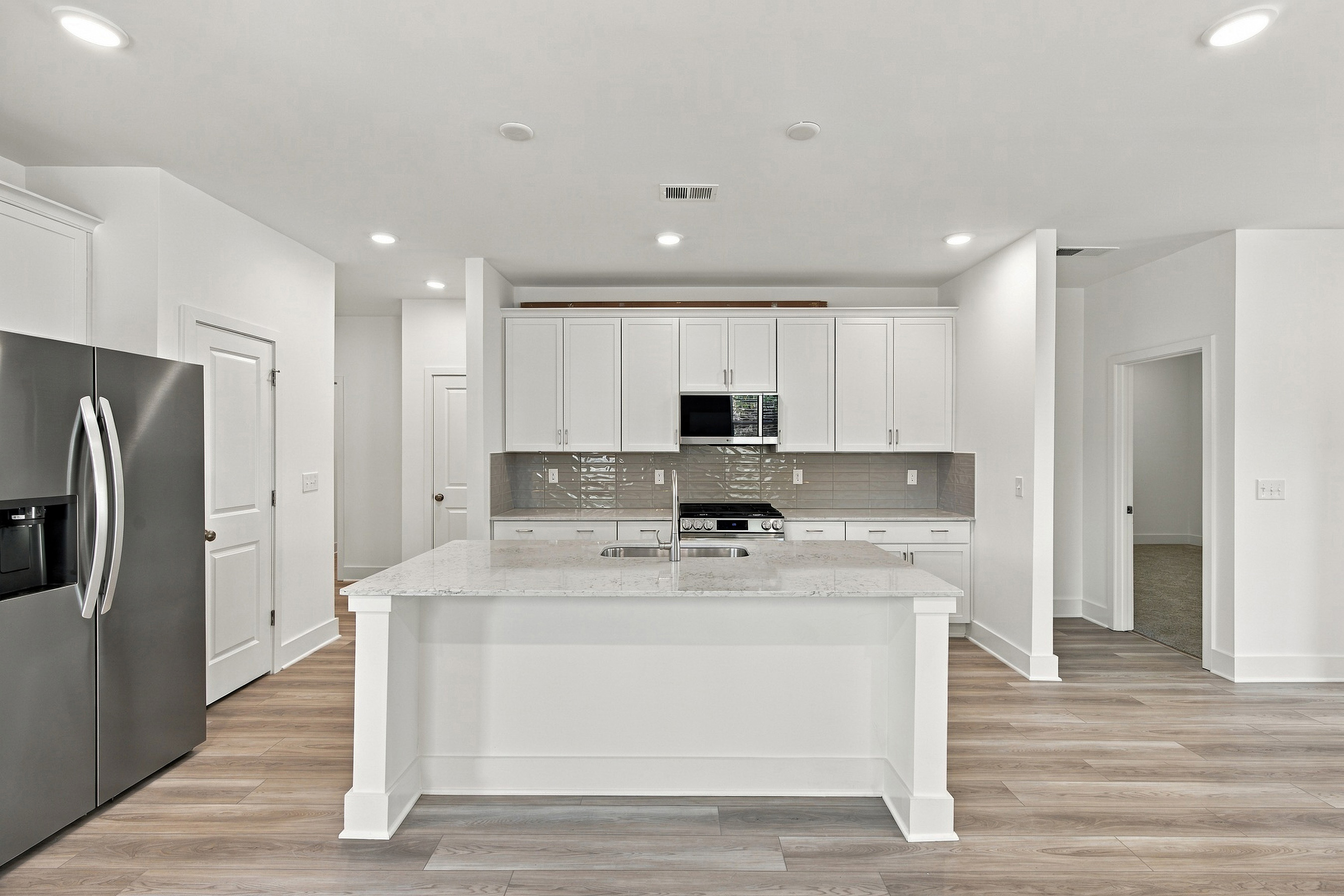 A kitchen with white cabinets.