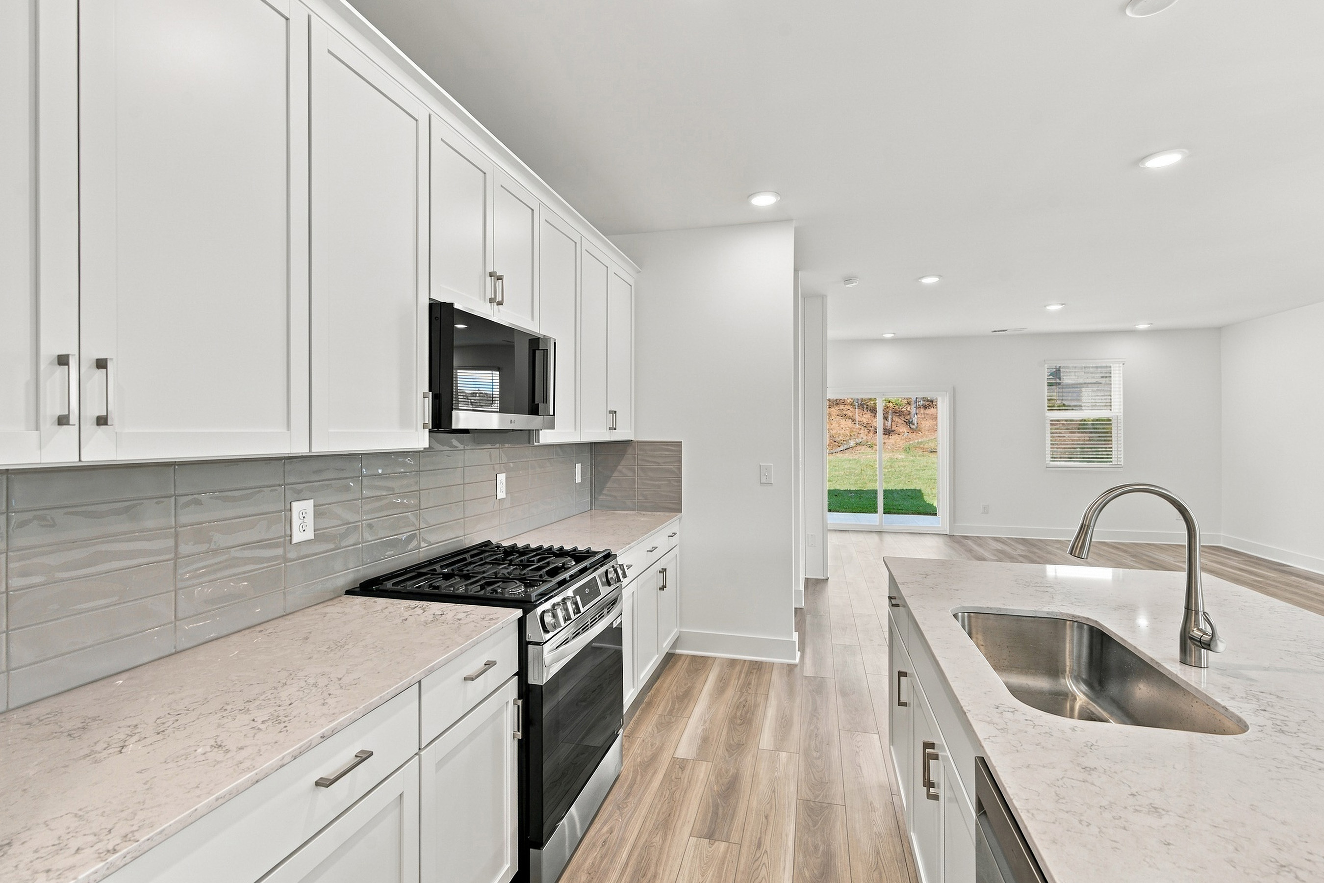 A kitchen with white cabinets.