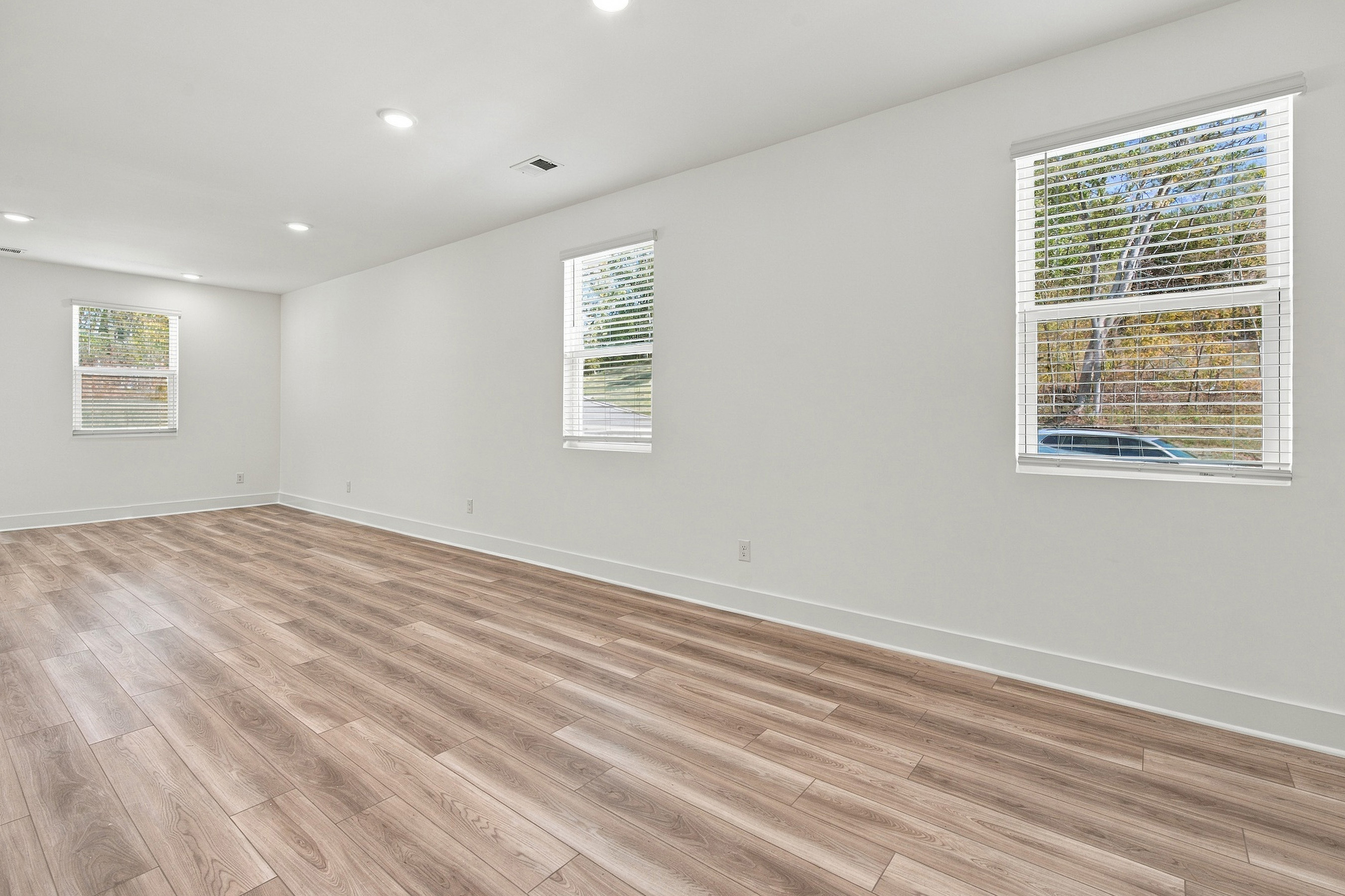 A room with a wood floor and windows.