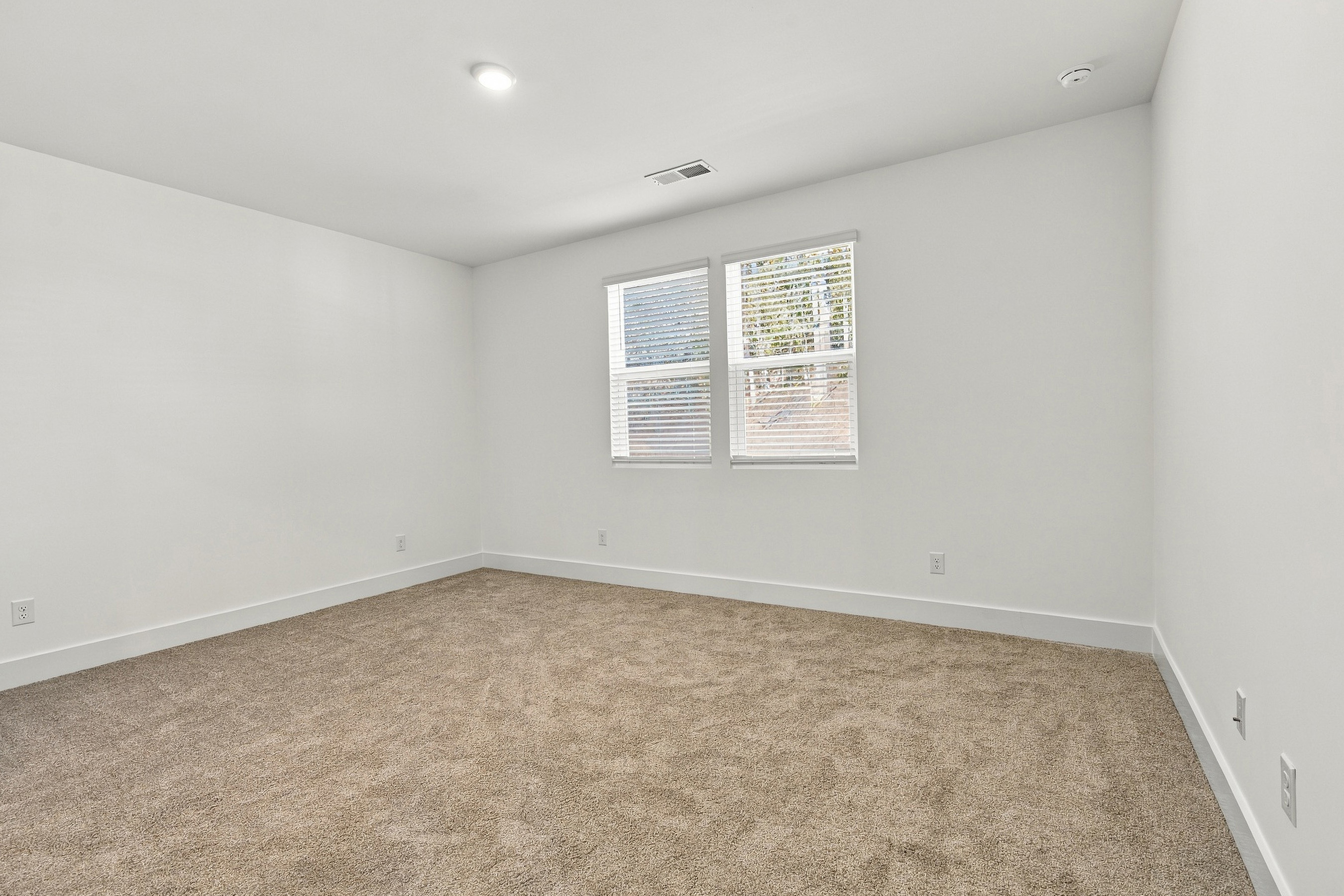 A room with a carpet and a window.
