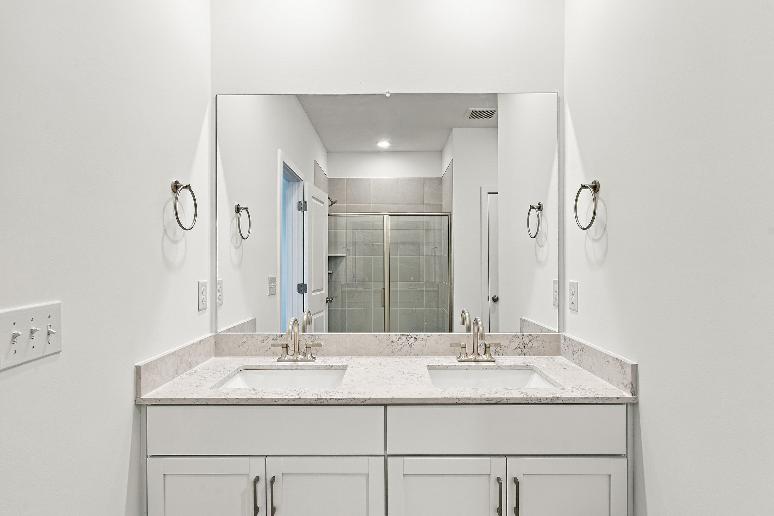 A bathroom with a large mirror.