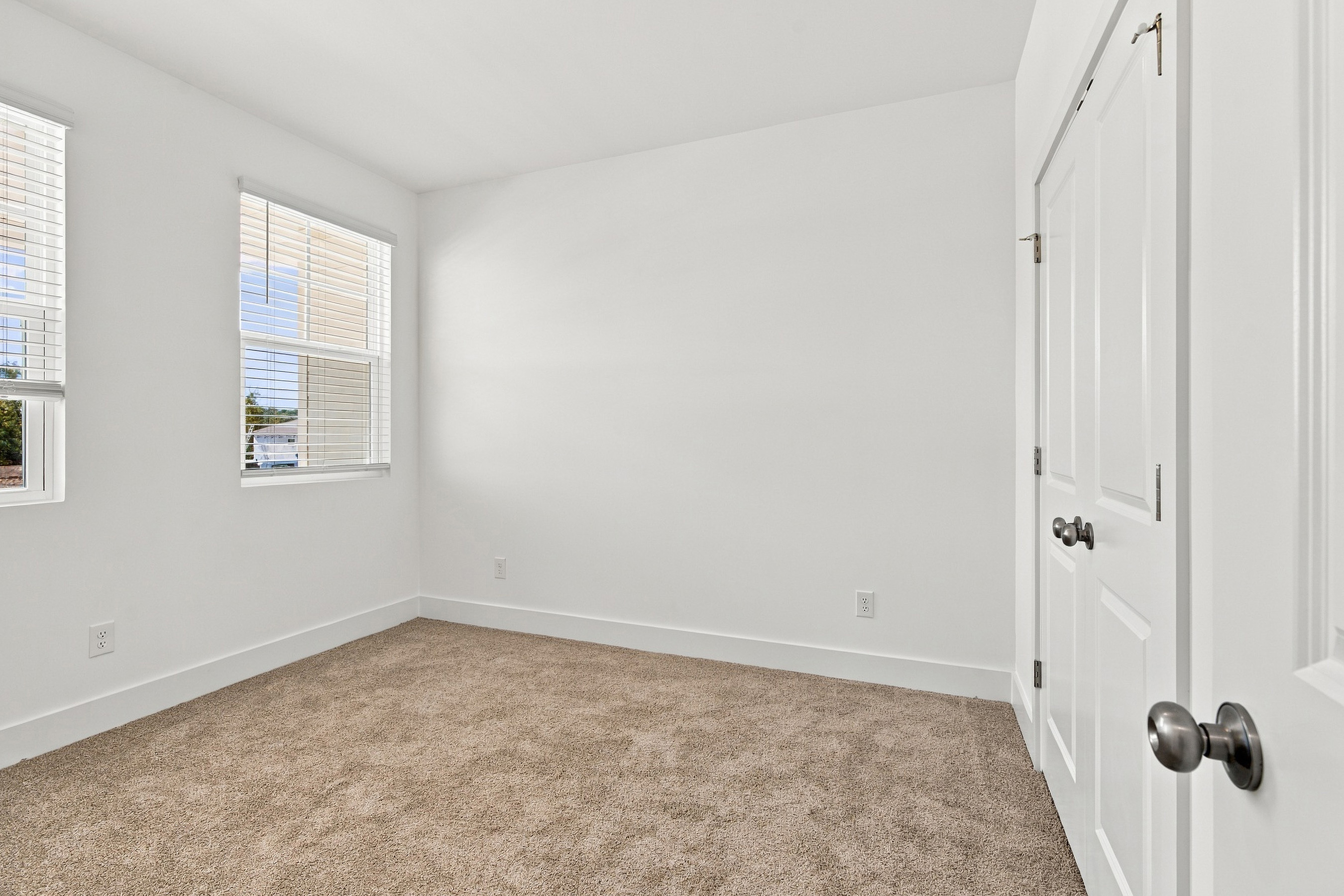 A room with white walls and a carpet.