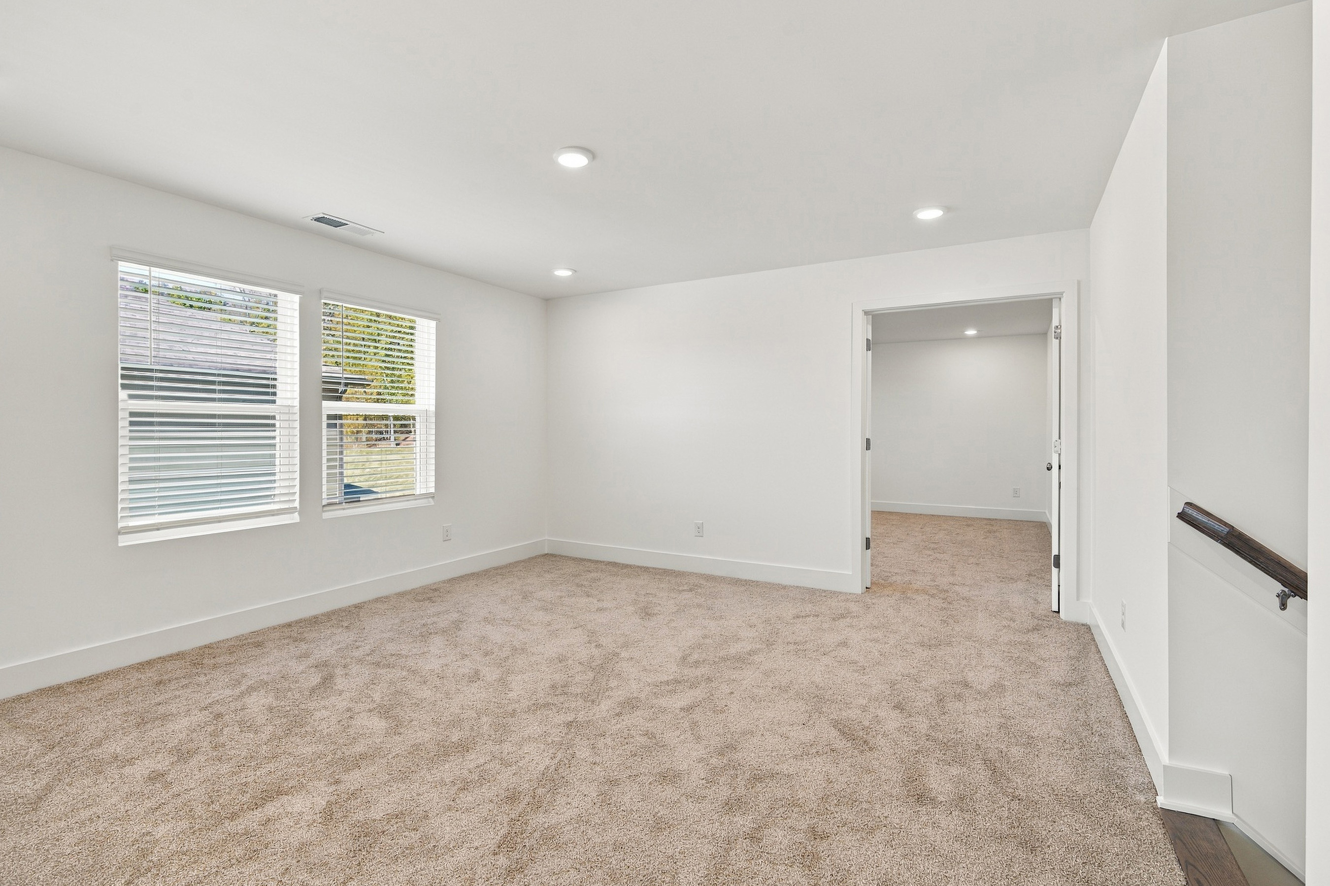 A room with a carpet and a door.