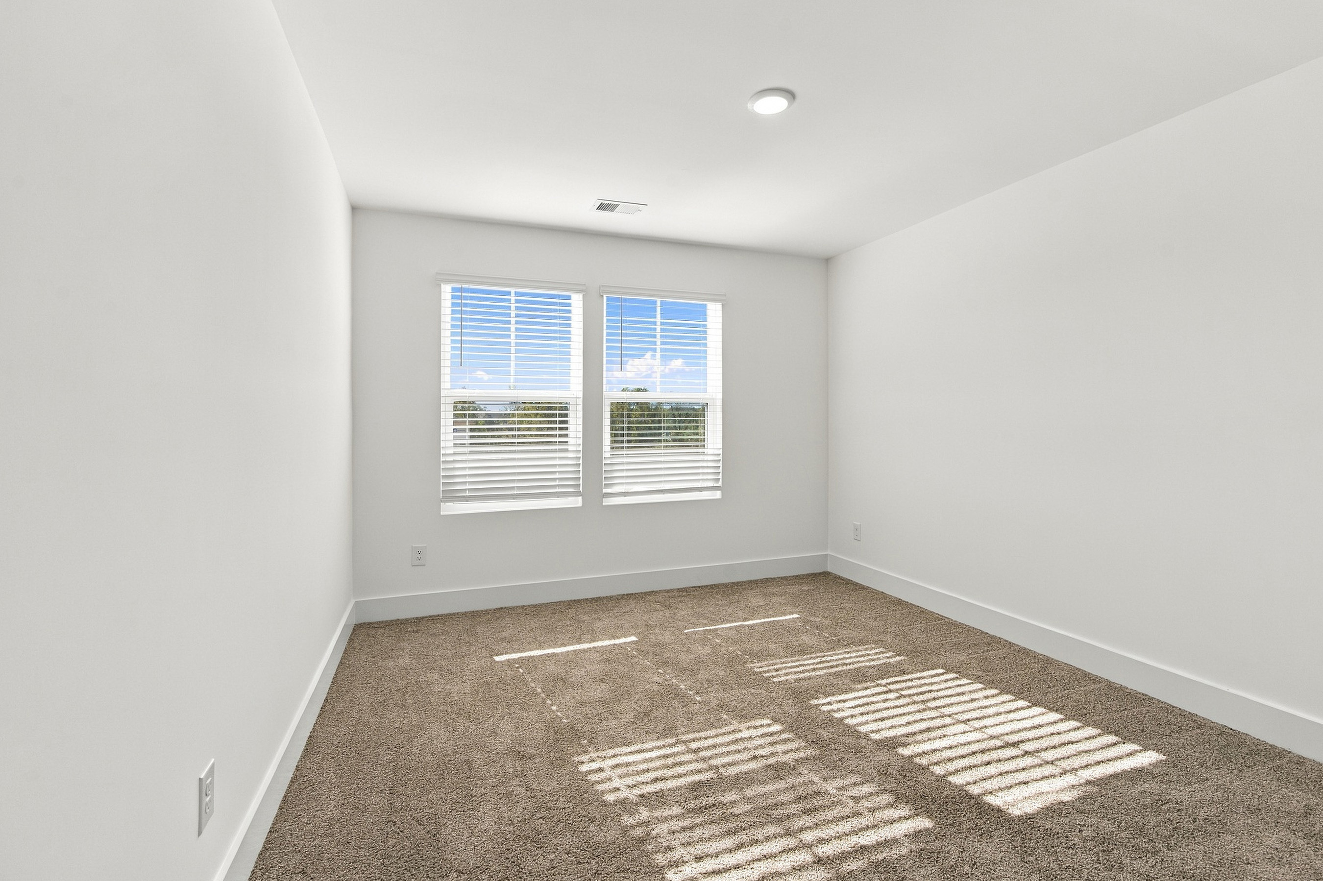 A room with a rug and a window.