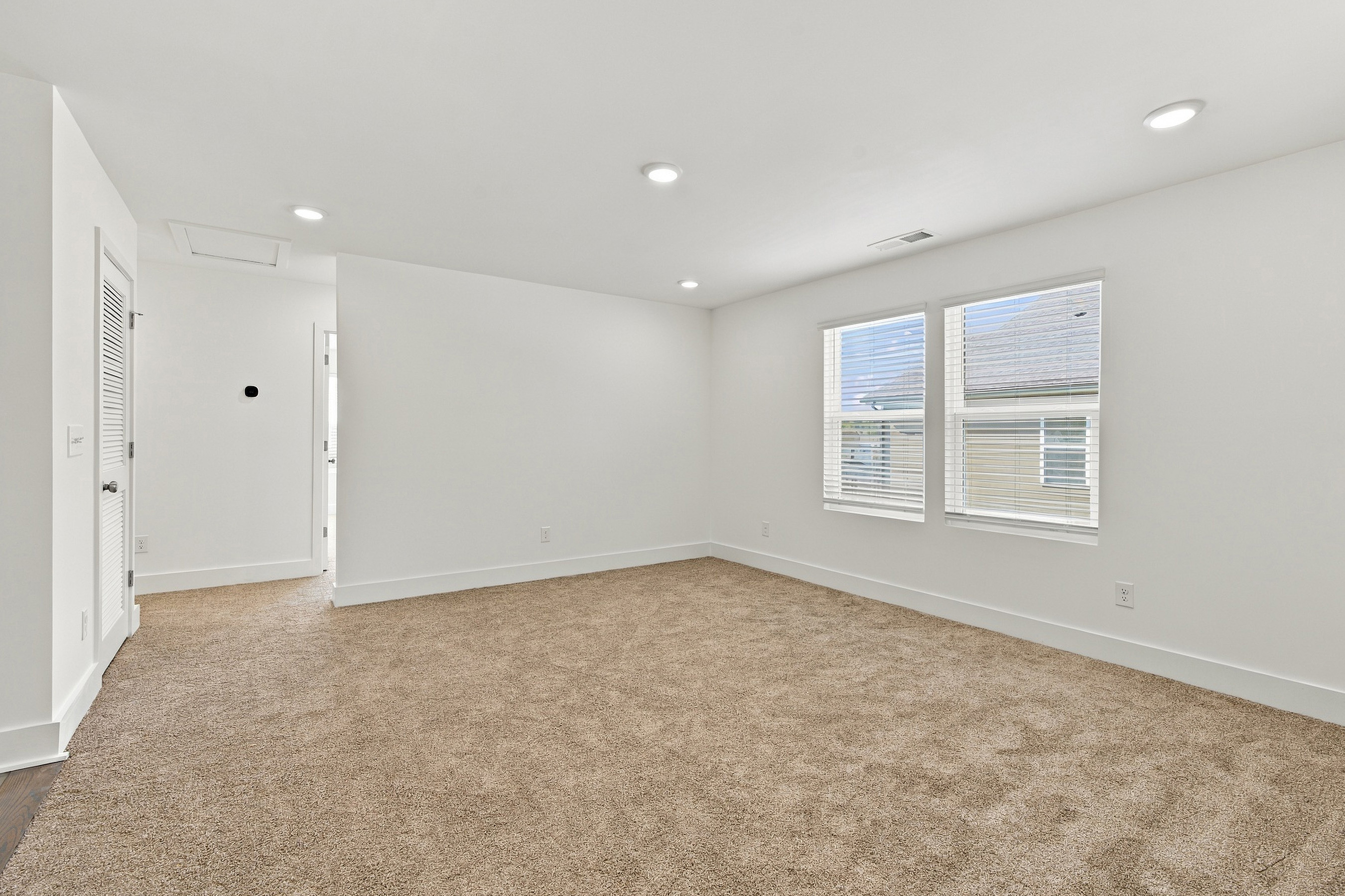 A room with a carpet and a window.