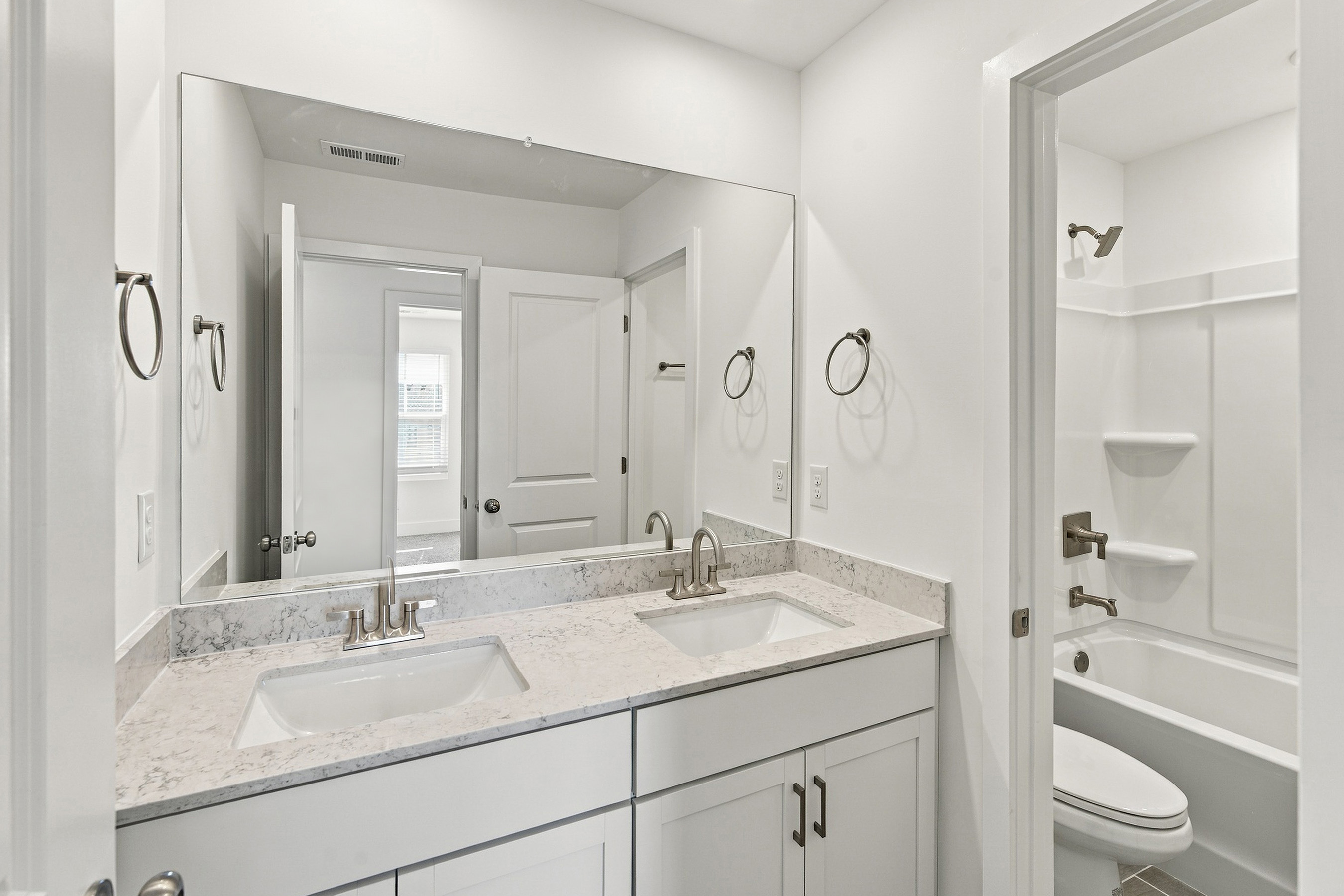 A bathroom with a large mirror.